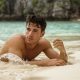 Man laying on a beach in the sand