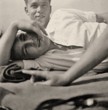 A vintage photo of a young gay couple cuddling.