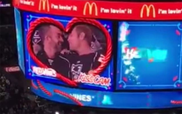 This is a photo of a gay couple kissing at a hockey game.