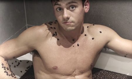 This is a photo of Tom Daley in a bathtub filled with coffee beans.