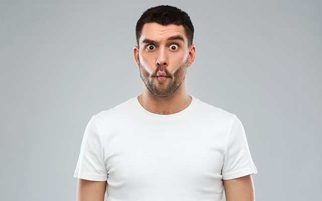 Man with funny fish-face over gray background.
