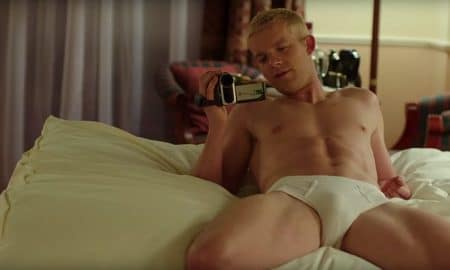Russell Tovey laying on a bed in his underwear