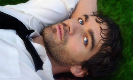 Man with blue eyes laying in the grass