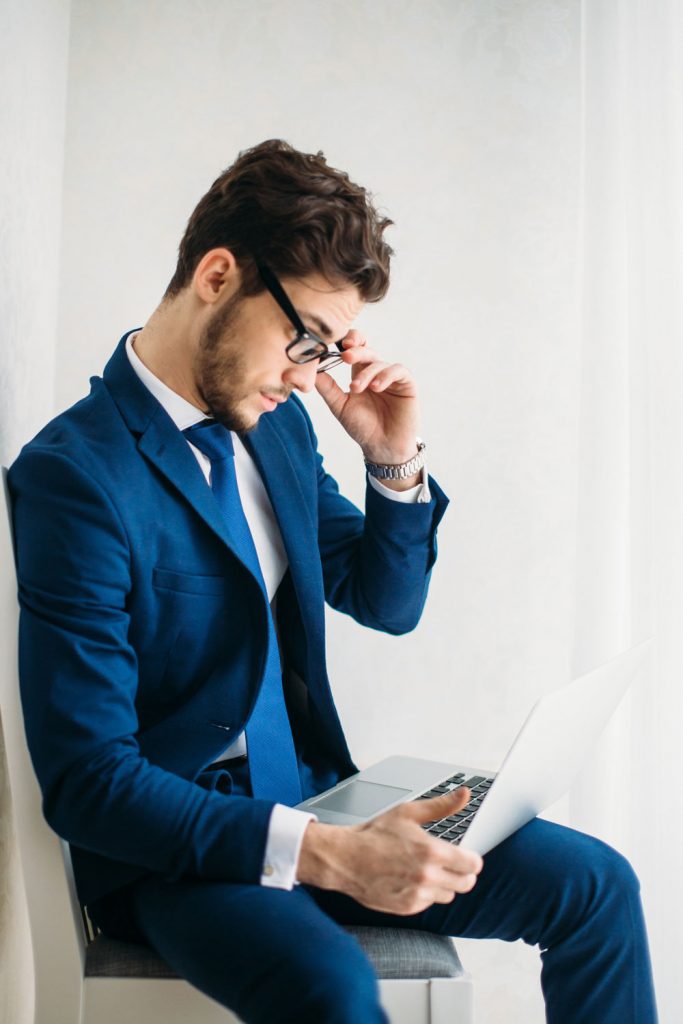 A young man in a suit working on a computer