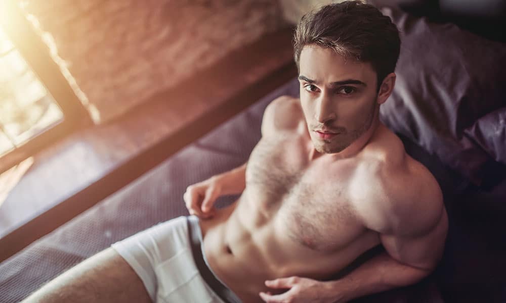 Man moisturize in underwear in bed