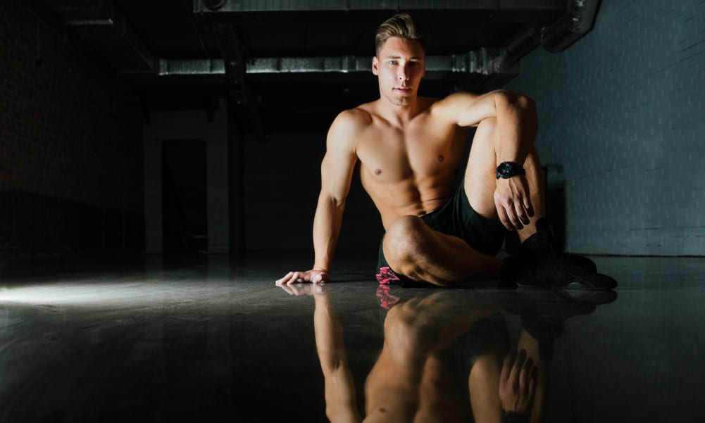 Male model sitting on gym floor