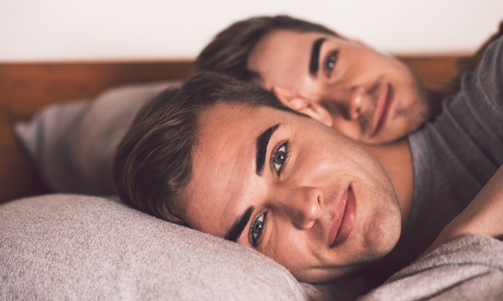 Young gay couple in bed