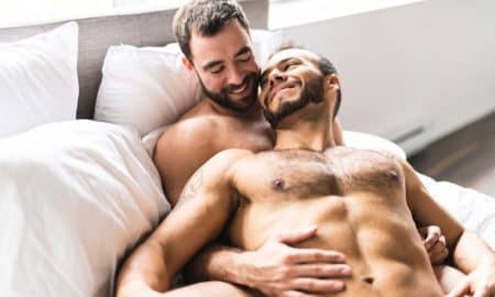 This is a photo of two men cuddling in bed.