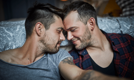 Affectionate gay couple with closed eyes at home