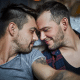 Affectionate gay couple with closed eyes at home