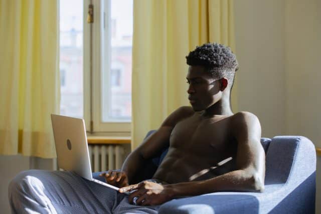 Shirtless man on laptop