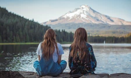 Two Women Sitting on Rock Facing Hood Mountain