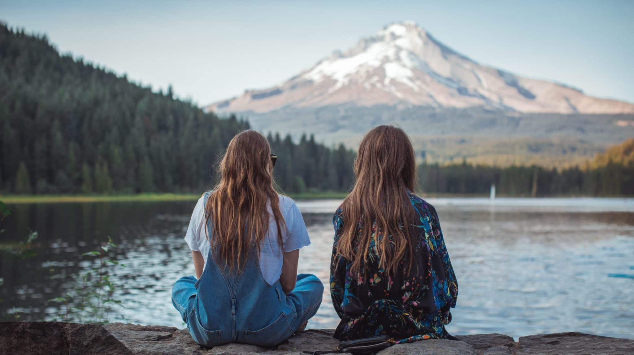 Two Women Sitting on Rock Facing Hood Mountain