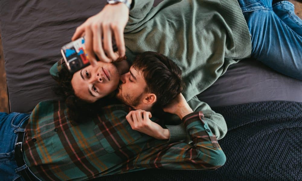 Gay couple on bed with iphone