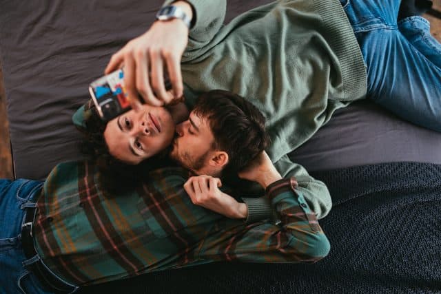 Gay couple on bed with iphone