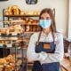 Woman working at a bakery wearing a face mask to avoid the coronavirus.