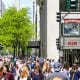 A crowded shopping street with lots of pedestrians, some green trees and Retail-Shops in Chicago.
