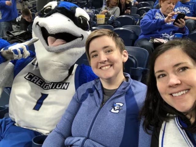 Set the Bar owner Molly Huyck, right, with her late sister, Kelsey, and Creighton University mascot Billy Bluejay at a women's basketball game in Omaha, Neb., in 2018.